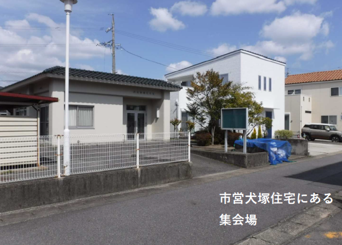 ⻄尾市営犬塚住宅 集会所の全体写真（道から少し登ったところにある平屋の建物）