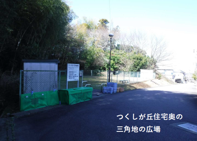 つくしが丘6丁目児童遊園の全体写真（木々に覆われた公園が道路の奥に広がる）