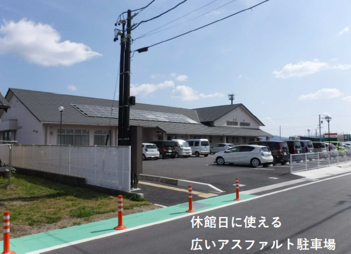 矢田ふれあいセンター 駐車場の全体写真（入り口から続くアスファルト駐車場と奥に矢田ふれあいセンターが見える）