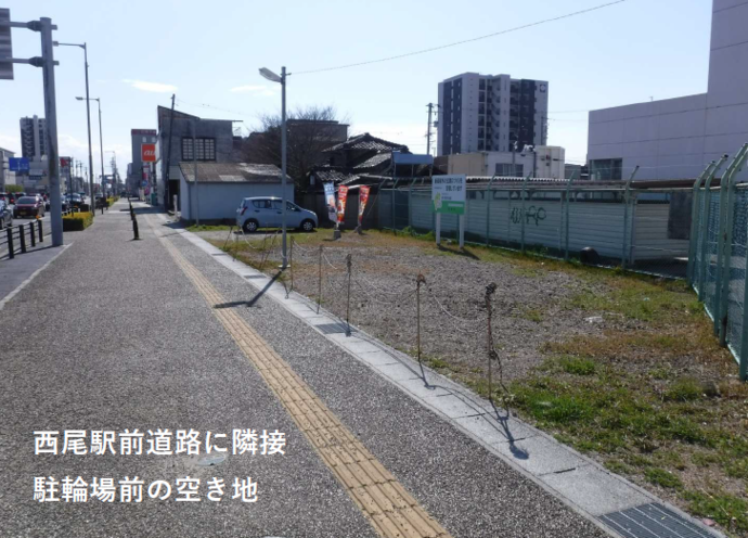 ⻄尾駅⻄再開発事業用地 東側の全体写真（駐輪場前にある看板の立った空き地）